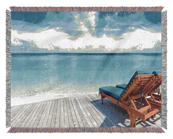 sunchairs on decking on the beach Woven Blanket