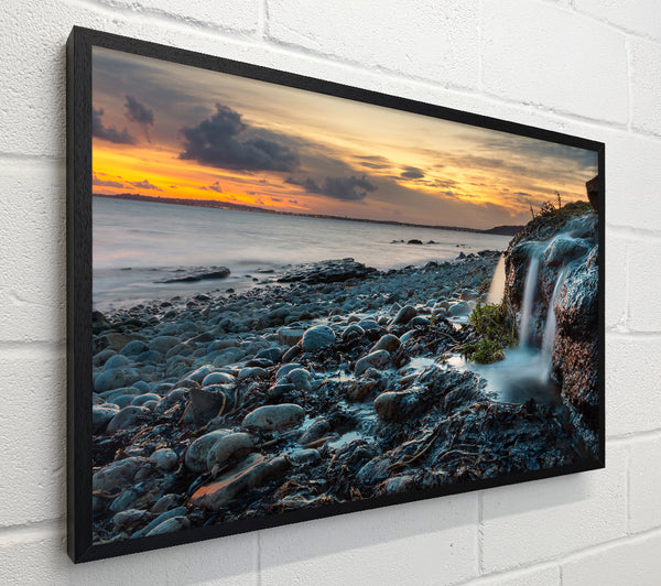 Water flows down the rocks into the sea