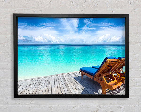 sunchairs on decking on the beach Framed Print