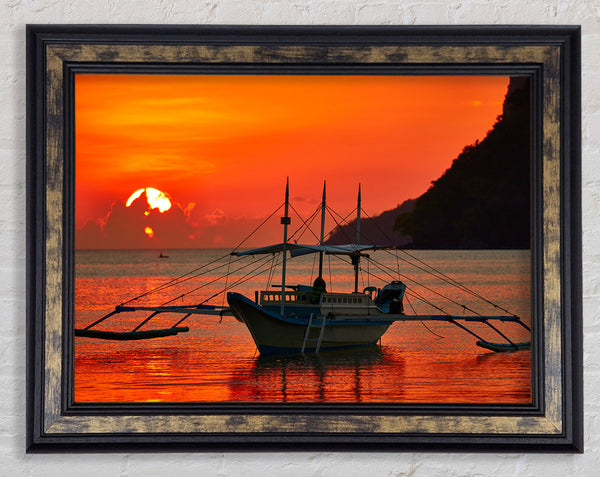 Boat sailing in the orange sunset Framed Print