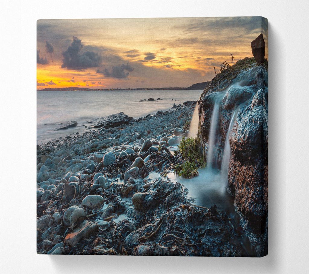 A Square Canvas Print Showing Water flows down the rocks into the sea Square Wall Art