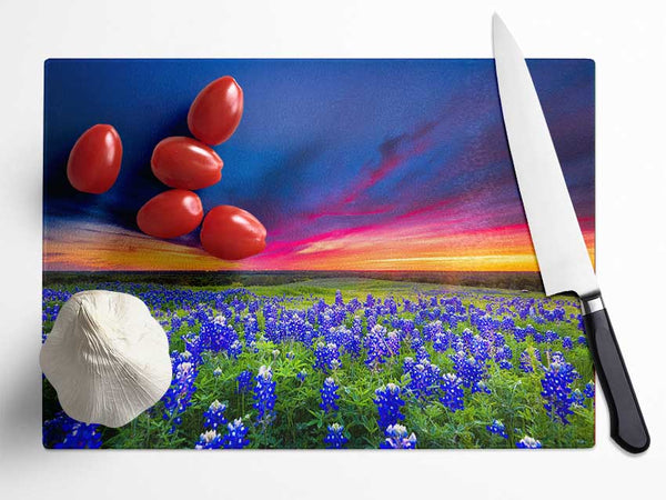Vibrant skies above blue flowers Glass Chopping Board